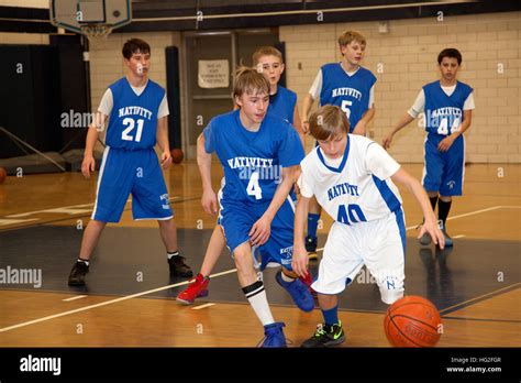 Young Teen Boys Age 13 Playing Basketball In School Gymnasium St Paul