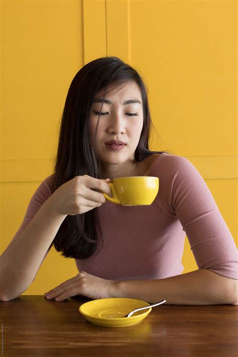 Asian Woman Drinking Coffee Holding A Yellow Cup By Stocksy