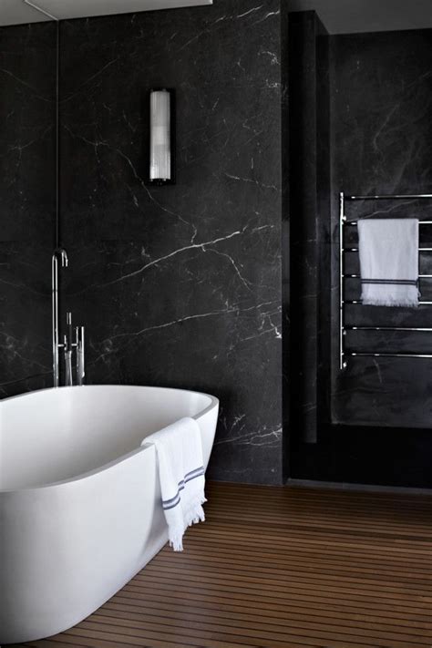 The bathroom are tiled with hex marble tile on the floor and herringbone marble tiles in the shower. How Black Marble Can Make Your Home More Glamorous