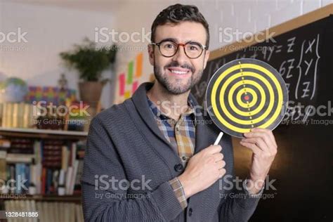 Stressed Out Teacher Holding Bullseye Target In Classroom Stock Photo