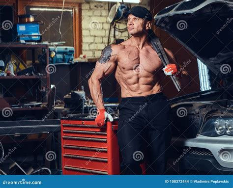 Bodybuilder Mechanic Opening Coverall To Show Muscular Body Royalty Free Stock Image