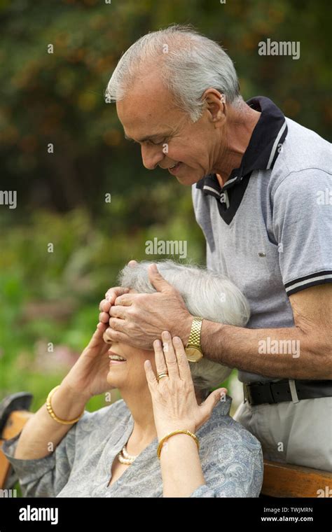 Old Man Covering Womans Eyes From Behind And Smiling Stock Photo Alamy