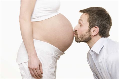 Man Kissing Pregnant Woman S Belly Side View Stock Photo