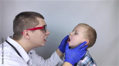 Stockvideo A Pediatrician Examines A Boy Who Complains Of A Sore Throat