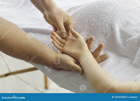 Male Masseur Doing Relaxing Hand Massage To Young Woman Lying On Massage Table In Spa Stock