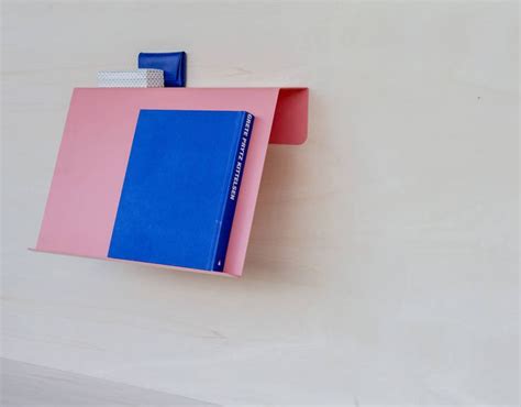 A Pink And Blue Book Is Hanging On The Wall