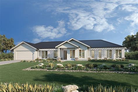 a white house sitting on top of a lush green field under a blue cloudy sky