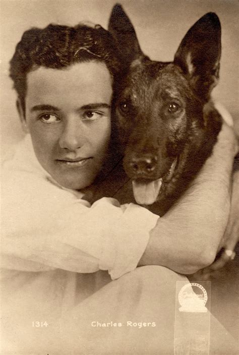 An Old Black And White Photo Of A Man Holding A Dog In His Arms With