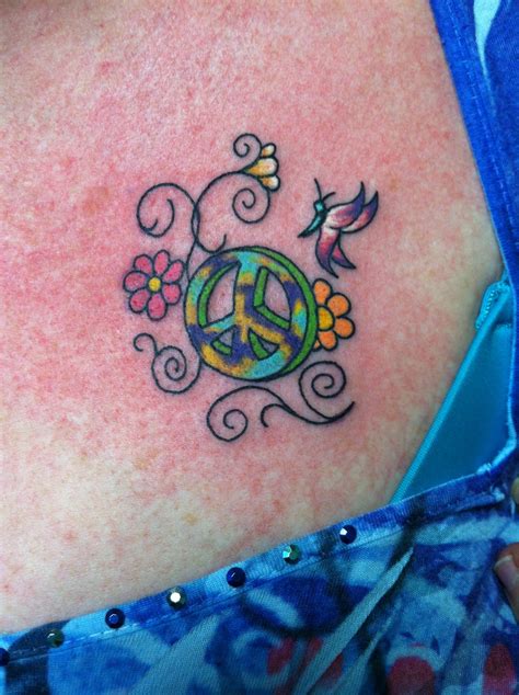 A Woman With A Peace Sign Tattoo On Her Back