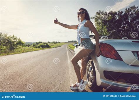 bella donna che fa l autostop con un auto rotta bella ragazza sexy in pantaloncini corti sta