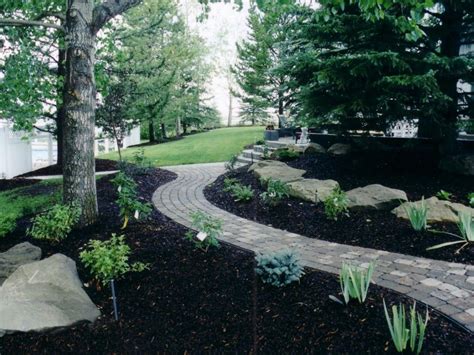 Black Mulch Complimenting The Charcoal Cobblestone Backyard