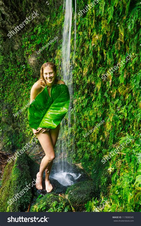 Beautiful Woman Relaxing Under Tropical Waterfall In Hawaii Stock Photo