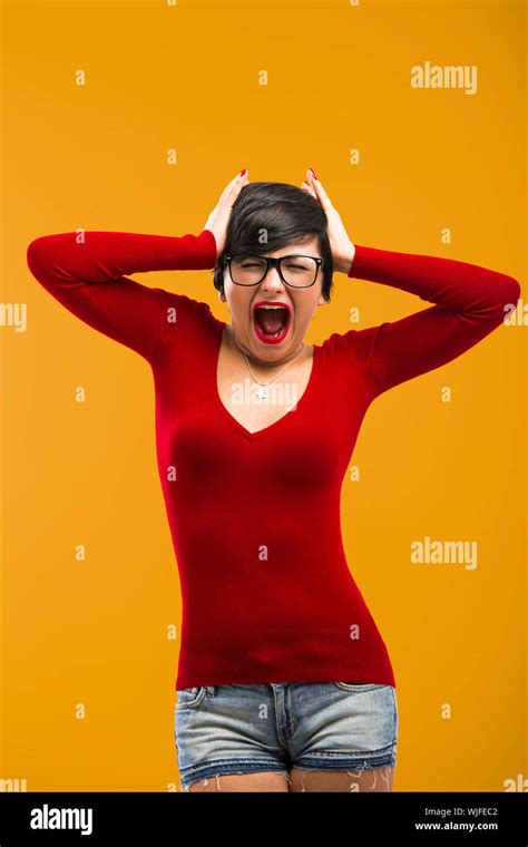 Nerd Girl Angry With Something Aganist A Yellow Background Stock Photo