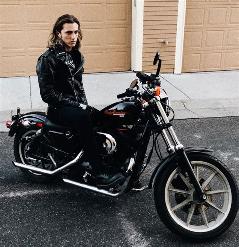 A Photo Of A Handsome Male Biker With Long Wavy Hair Sitting On His Hd