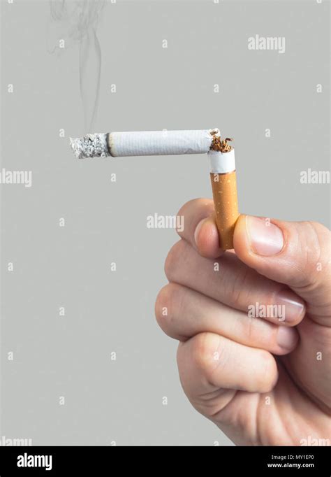 Homme avec une cigarette allumée à la casse dans sa main symbole de l