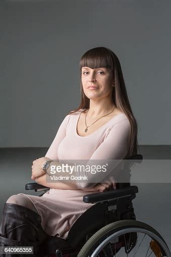 Portrait Of Confident Disabled Woman In Wheelchair Against Gray