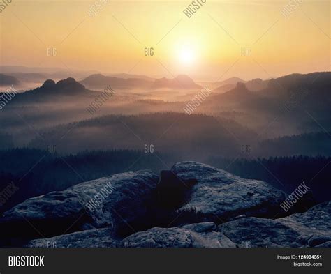 Fantastic Dreamy Sunrise On Top Of Rocky Mountain With View Into Misty