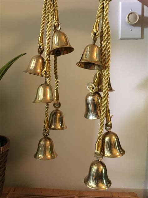 Several Bells Hanging From A Wall Next To A Potted Plant