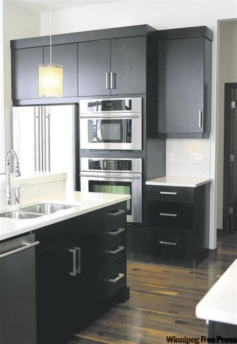 Considering a quartz kitchen countertop? Dark expresso cabinets topped with white quartz ...