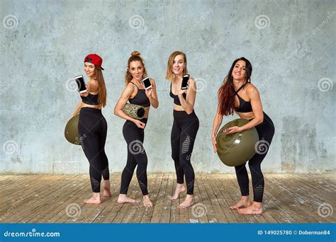 A Group Of Beautiful Fitness Girls In A Fitness Room Near A Gray Wall With A Props For Training