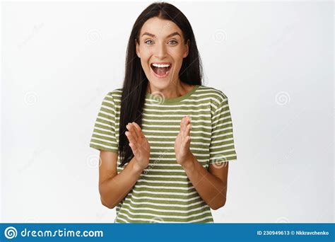 excited smiling woman clap hands looking fascinated and applausing standing in t shirt over