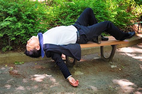 Passed Out Man In Tokyo Park Daytime Profile Full Length Stock Photo