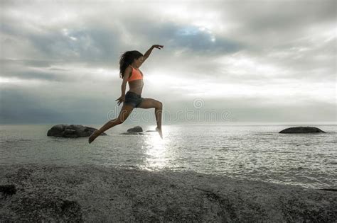 Woman Jumping On A Rock At Sunset On Bakovern Beach Cape Town Stock Photo Image Of Jump