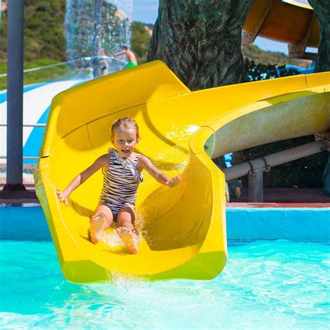 Little Girl On Water Slide At Aquapark During Stock Photo Image Of