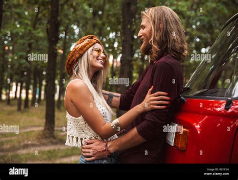 beautiful hippy couple man and woman smiling and hugging each other while walking in forest