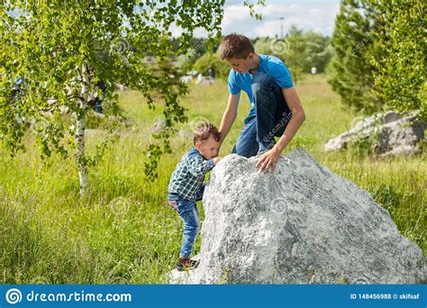 Children Help Each Other To Climb The Rock Stock Photo Image Of