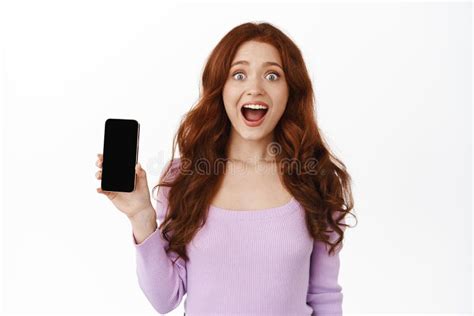 Excited Redhead Girl Screams From Happiness And Joy Shows Smartphone Blank Screen Recommends