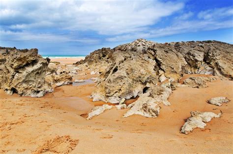 Strip Of Big Stones On The Sandy Beach During An Outflow Stock Photo