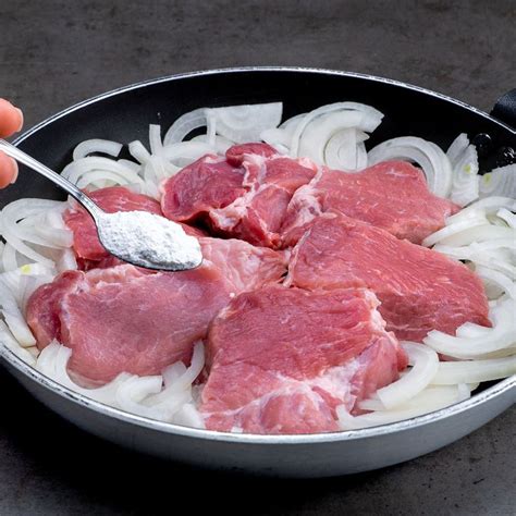 Someone Is Spooning Some Meat And Onions In A Pan