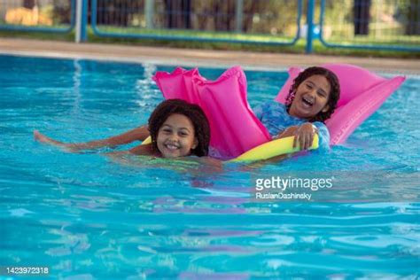 Little Girl Lying On Airbed Floating In Swimming Pool Photos And