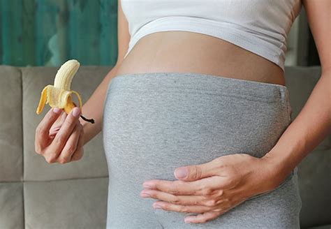 Premium Photo Pregnant Woman Holding Banana At Her Belly