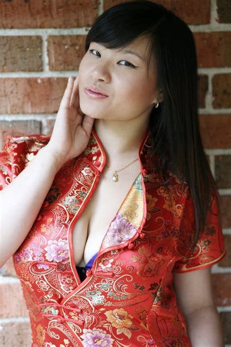 Menina sexy Asiática No Cheongsam Vermelho Com O Peito Da Mostra Da