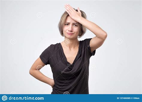 Portrait Of Forgetful Young Woman Against Gray Background Stock Image