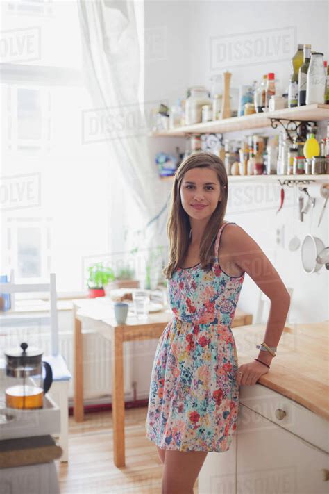 Portrait Of Beautiful Woman Standing By Counter In Kitchen At Home