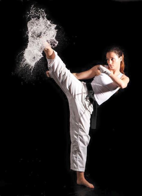 A Woman Is Doing Karate In The Dark With Water Splashing Out Of Her Leg