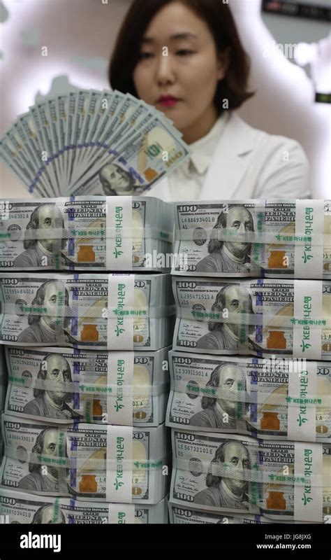 S Koreas Fx Reserves Up In April A Clerk Scrutinizes 100 Dollar Us Banknotes At The