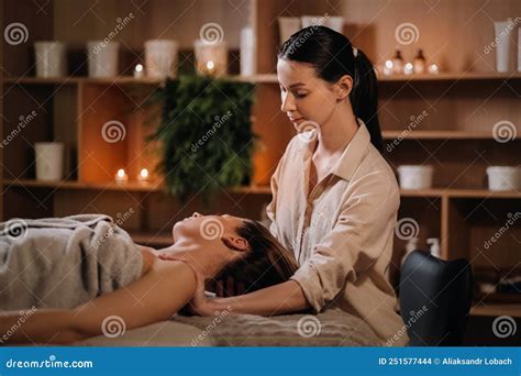 A Cosmetologist Girl Does A Facial And Neck Massage To A Girl In The Office For Skin Elasticity
