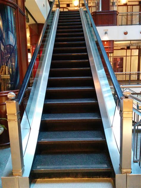 The Inside Of A Shopping Mall With Escalators Stairs