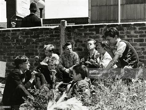 June 1957 A Group Of Boys Hidden Behinda Wall Smoking Cigarettes As