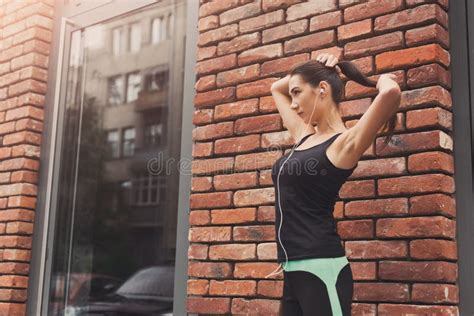 Beautiful Fitness Girl Posing On Brick Wall Background Stock Photo