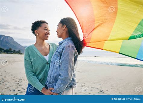 gay flag and lesbian couple at the beach for travel freedom and bond