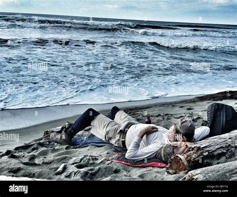 Man Sleeping On Beach By Sea Stock Photo Alamy