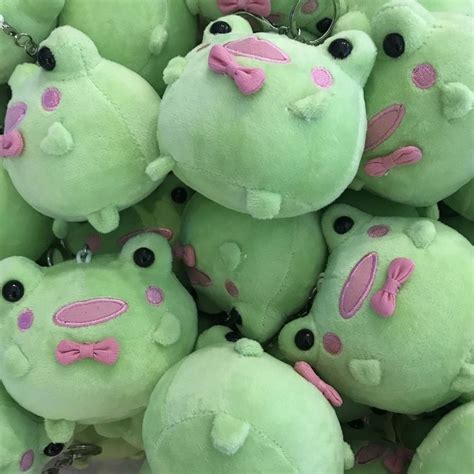 A Pile Of Green Stuffed Animals With Pink Bows