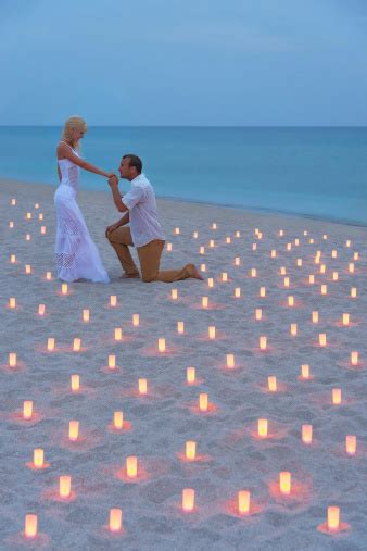 Marriage Proposal On The Beach With Candles At Sunset Stock Photo