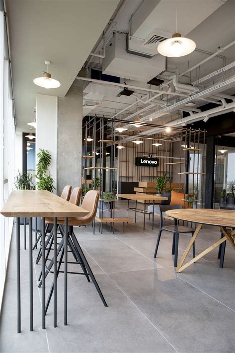 An Office With Tables Chairs And Plants In The Middle Of The Room On