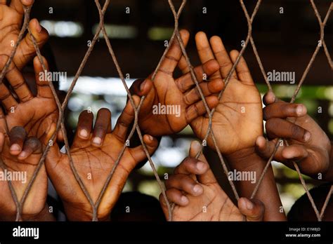 African Boys Hands Behind Wire Mesh Stock Photo Alamy